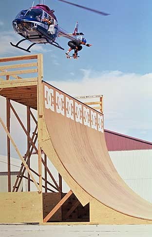 Skateboarder Danny Way jumps out of a helicopter with his skateboard onto a half-pipe