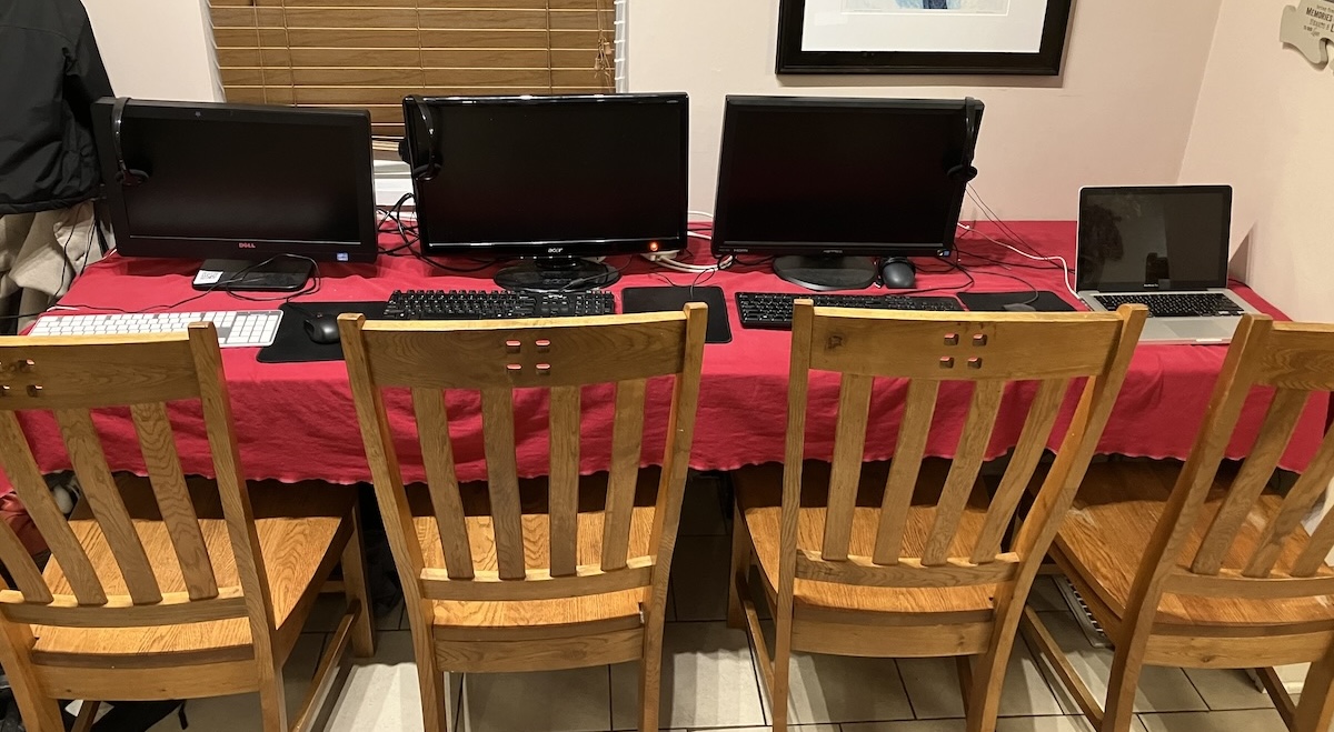 A photo of four computer workstations all side-by-side on a table.